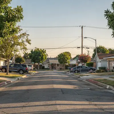 Residential street of ranch homes and mature trees in Bellflower, California