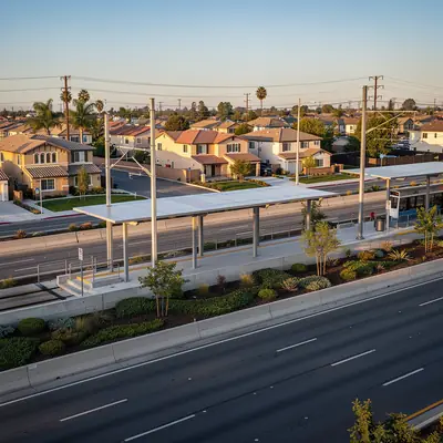 Light rail station in a freeway median with homes nearby in Lynwood, California